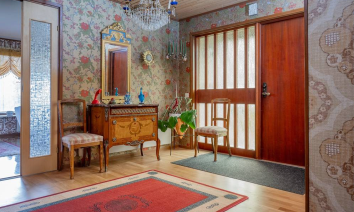 entrance to house with floral wallpaper and wooden door