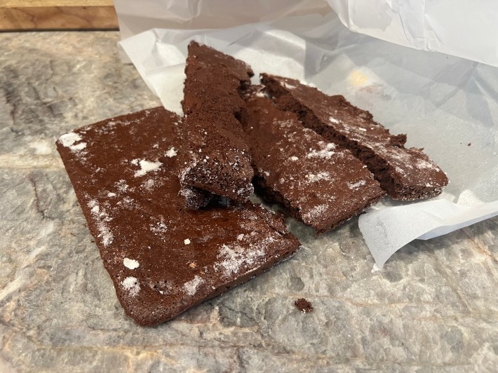 A chocolate sponge broken into four large flat strips.