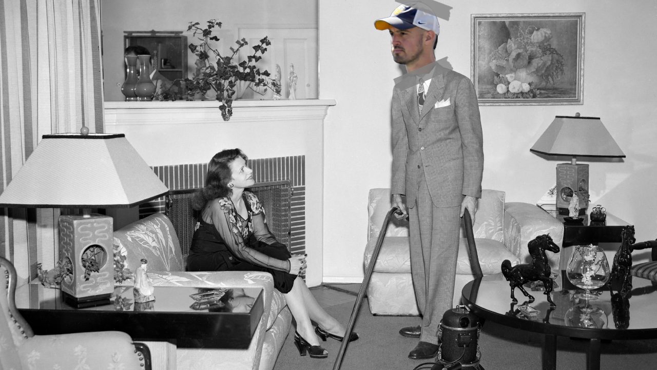 An old-timey black and white photo of a man in a house showing off a vacuum to a housewife. It's from 1953. And I've photoshopped the head of Connor Stalions onto the salesman’s head crudely. It is in color, unlike the rest of the photo, and the head is clearly held on with scotch tape.