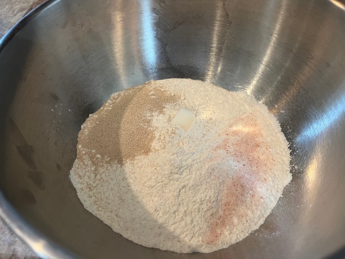 Flour, yeast, and salt in a large mixing bowl, plus a single small cube of lard.