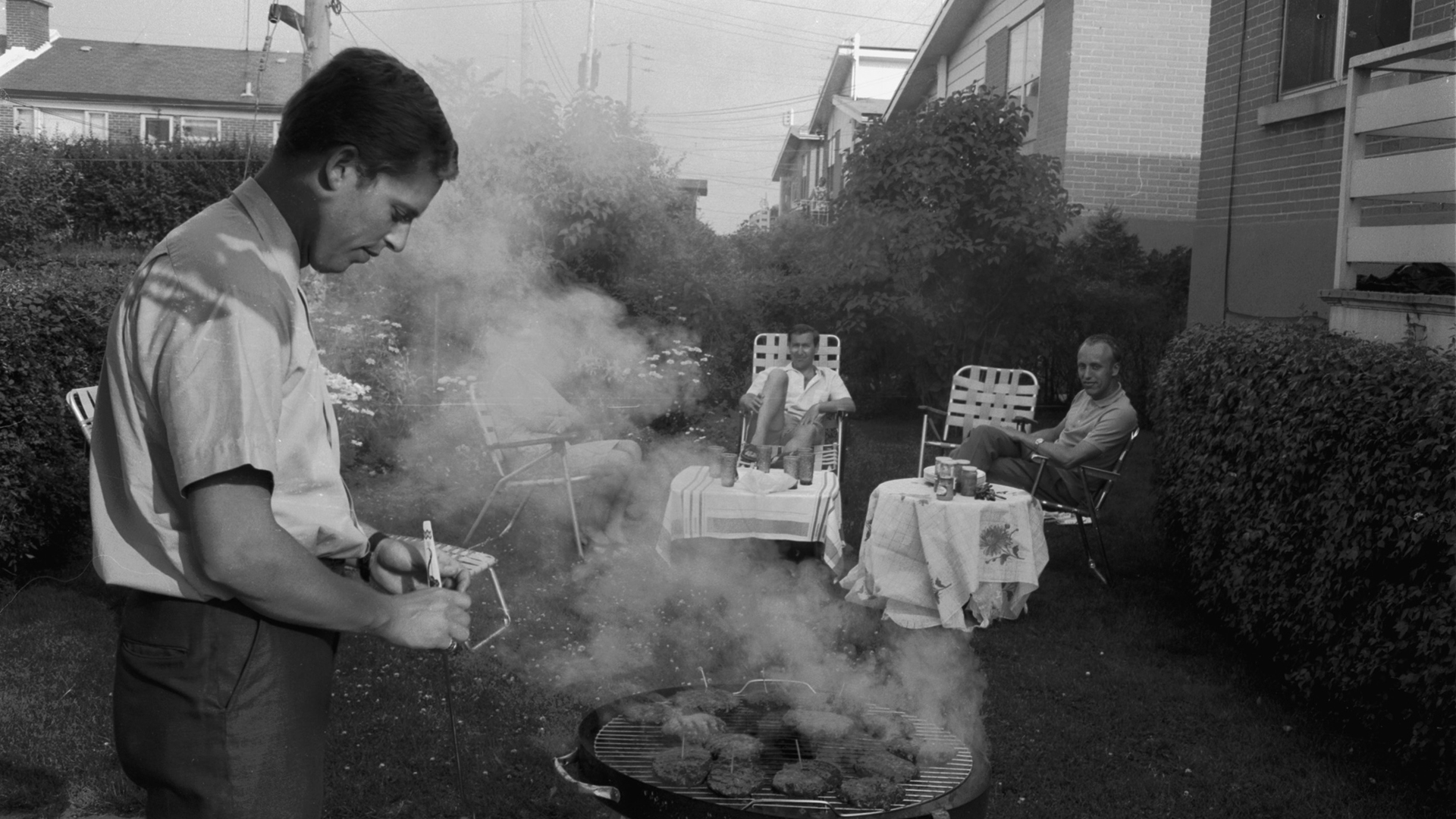 Canada - Montreal circa 1959, man grilling, BBQ with the family