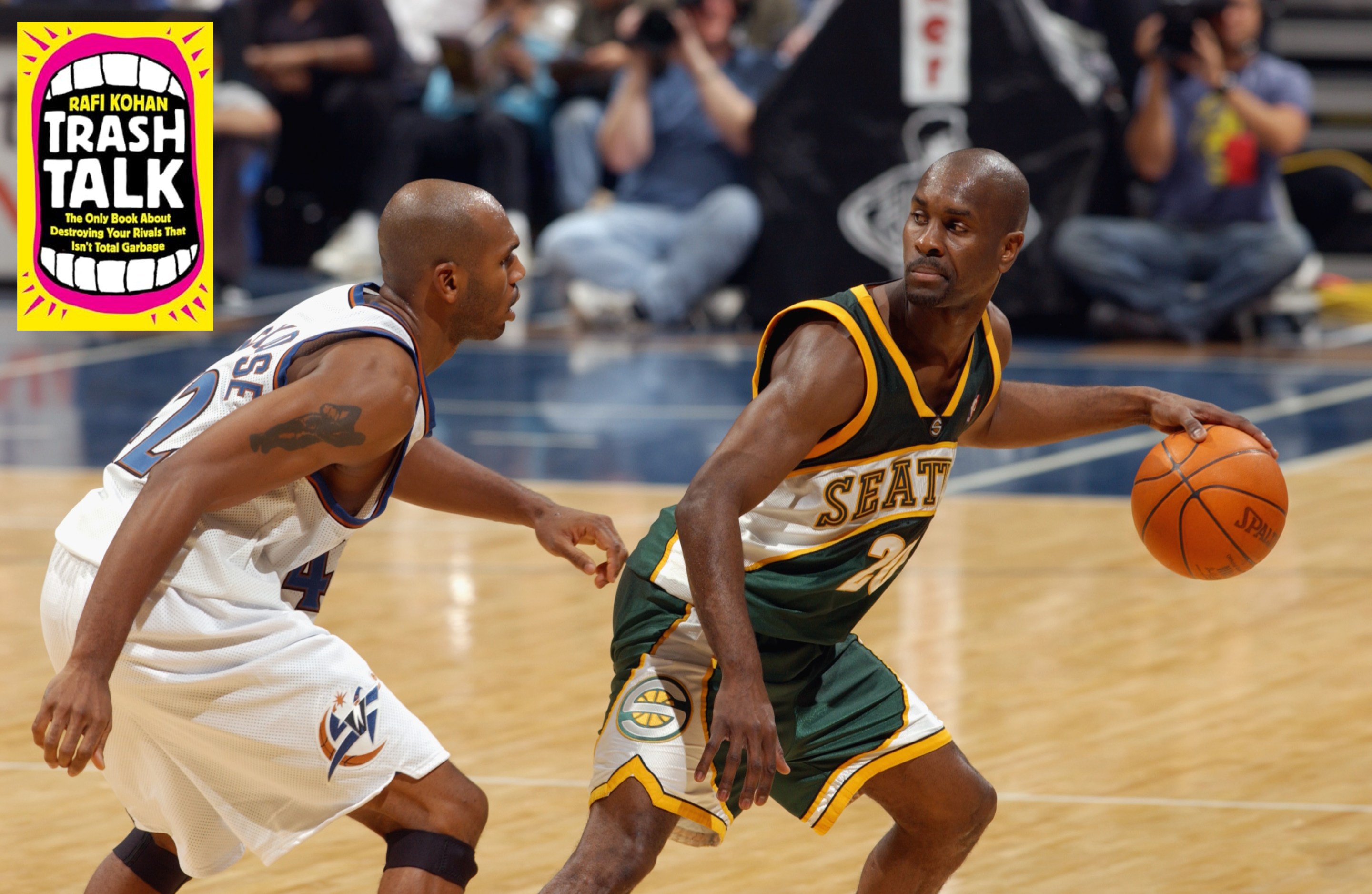 Gary Payton of the Seattle SuperSonics sneering disdainfully at Jerry Stackhouse, who is trying to guard him in 2002. The cover of Rafi Kohan's book "Trash Talk" is at upper left.