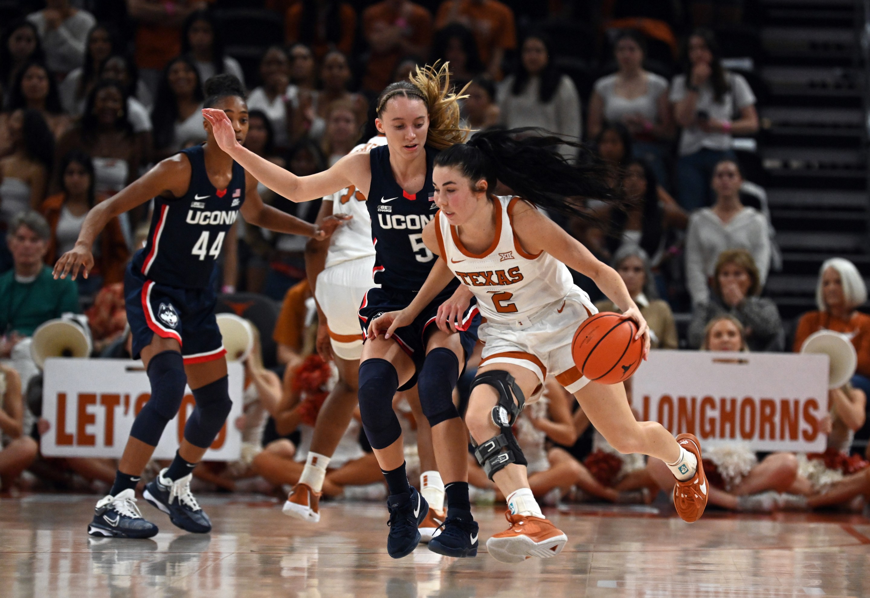 AUSTIN, TX - DECEMBER 03: Texas Longhorns guard Shaylee Gonzalez (2) drives past UConn Huskies guard Paige Bueckers (5) during game featuring the Connecticut Huskies and Texas Longhorns on December 3, 2023, at the Moody Center in Austin, TX.