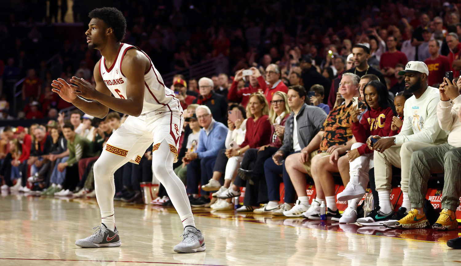 LOS ANGELES, CALIFORNIA - DECEMBER 10: Bronny James #6 of the USC Trojans looks to catch the ball as LeBron James (R looks on ) from the stands during the first half against the Long Beach State 49ers at Galen Center on December 10, 2023 in Los Angeles, California. (Photo by Katelyn Mulcahy/Getty Images)