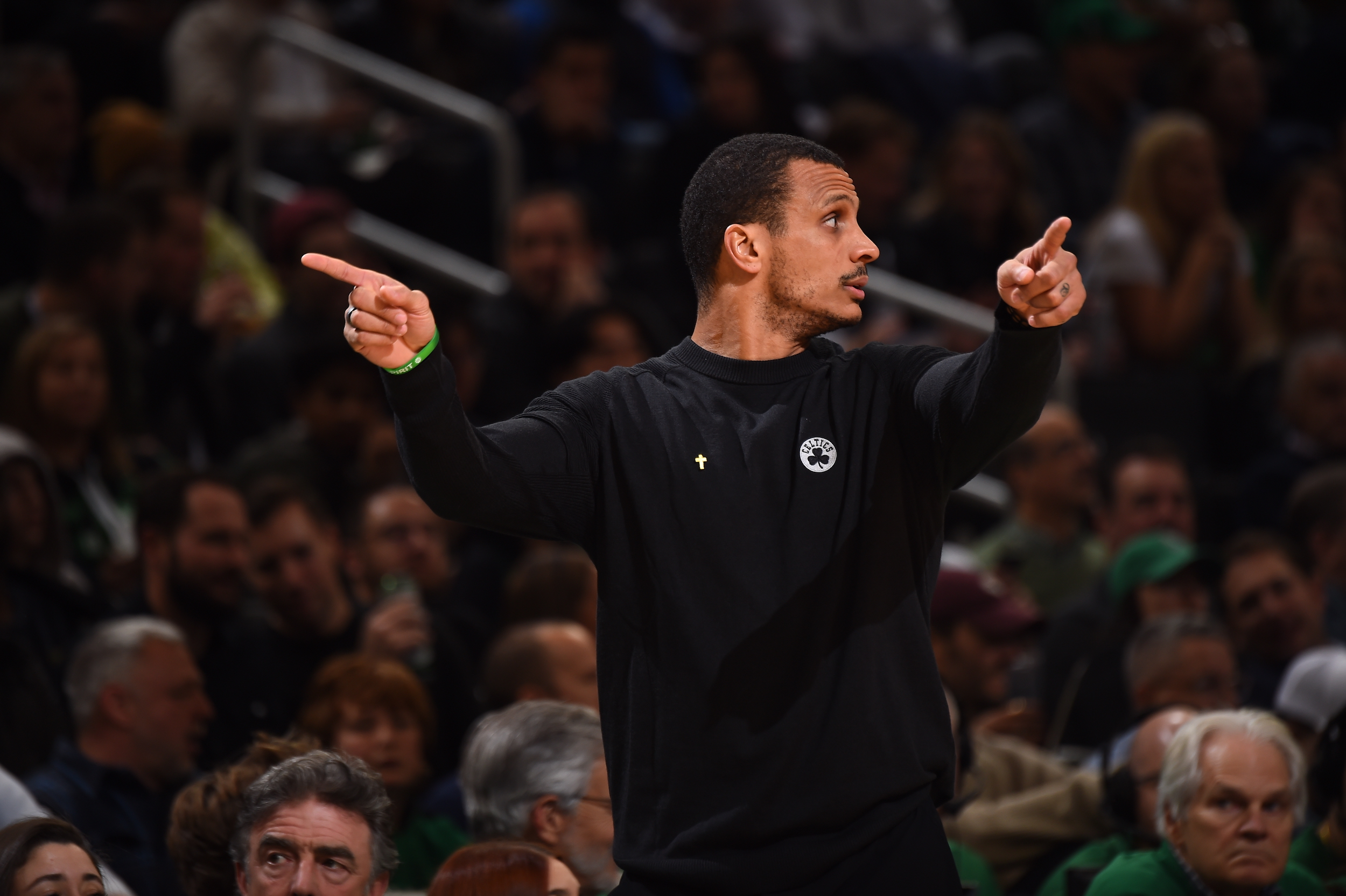 Celtics head coach Joe Mazzulla points in two directions while looking in a third.