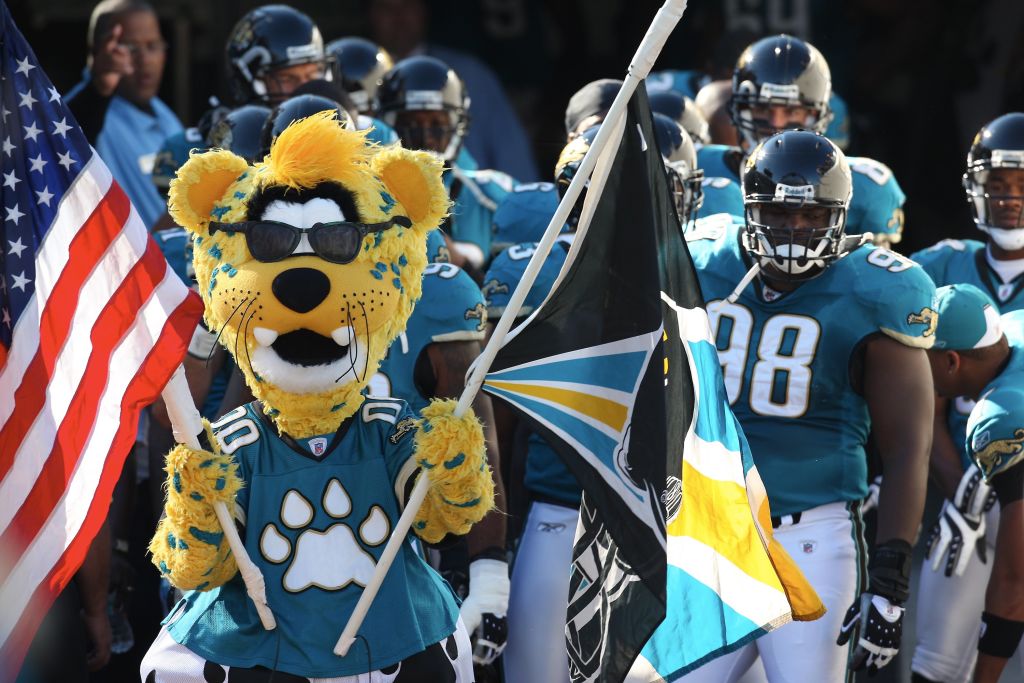 Jacksonville Jaguars mascot Jaxson de ville, wearing sunglasses and a jersey and carrying the team flag and American flag, leads the team onto the field against the Cleveland Browns in October 2008