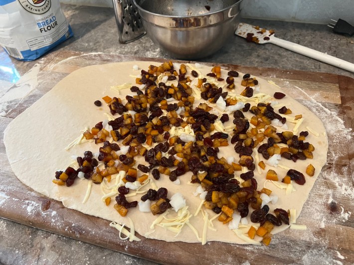 Filling plus lard and butter are strewn over a thin sheet of rolled dough.