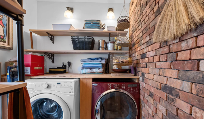 laundry room with brick accent wall