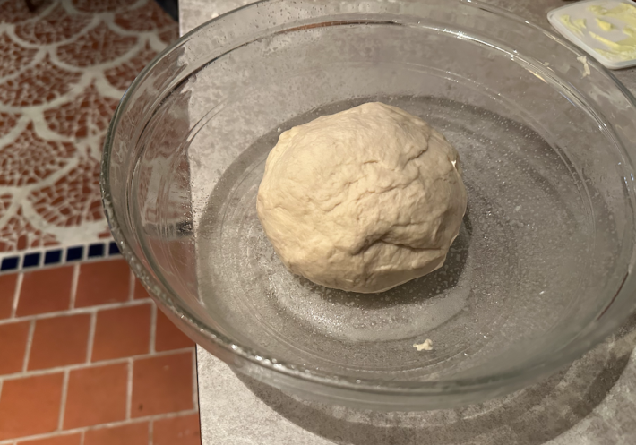 Dough in a glass bowl on the counter.