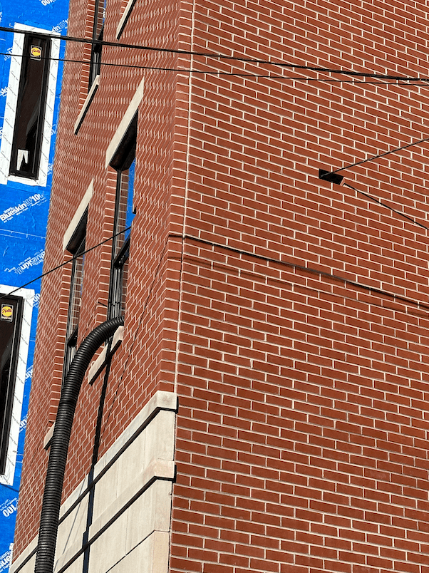 close up of missing brick with wire through it.