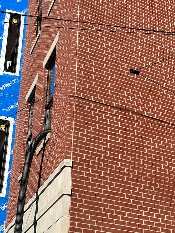 close up of missing brick with wire through it.