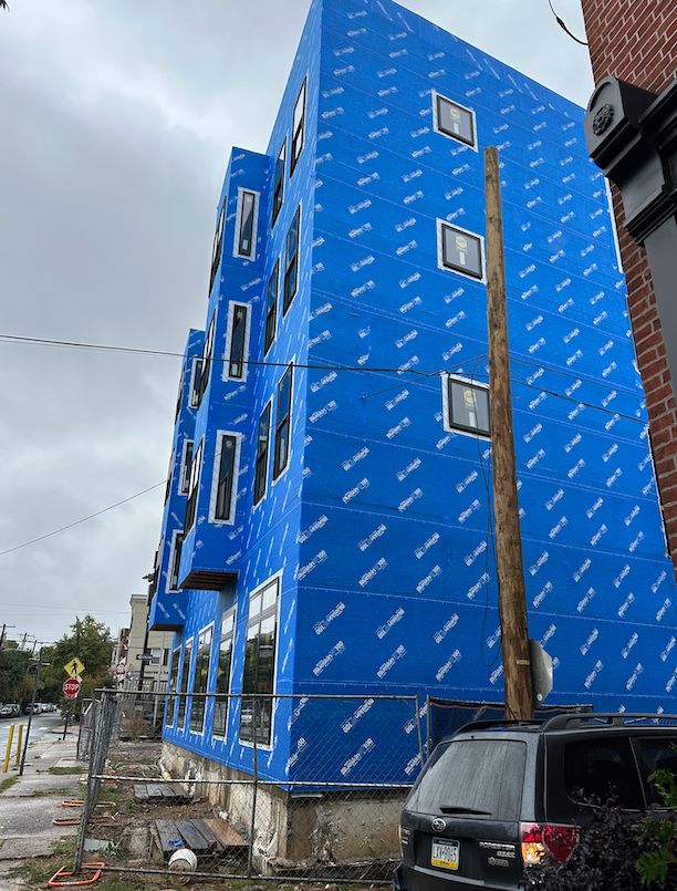 the wire going through the blue waterproofing on the building