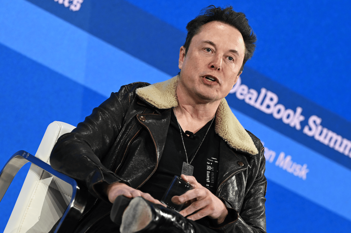 Elon Musk wearing a black leather jacket with a shearling collar to a stage interview with Andrew Ross Sorkin, lol.
