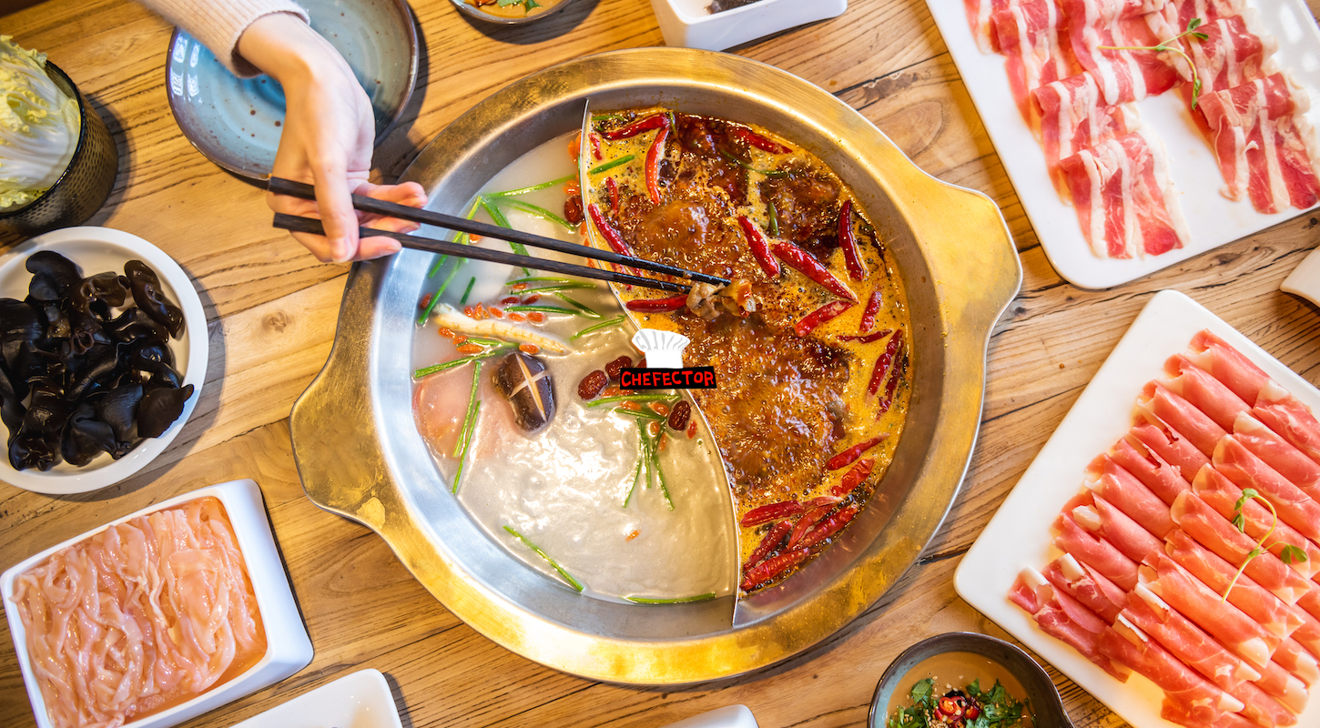 Hand taking food with chopsticks. Eating Hot Pot at restaurant