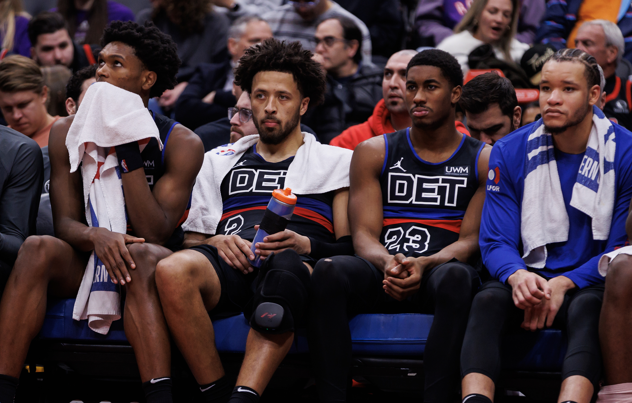 Pistons players sit on the bench during a blowout