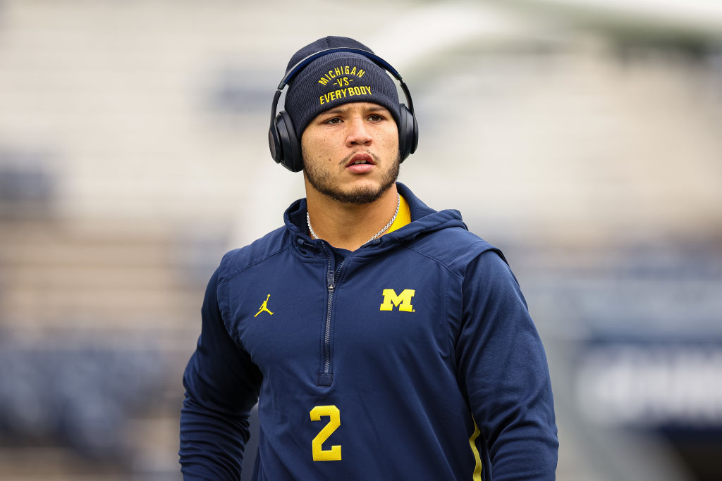 Blake Corum warms up for a game while wearing a Michigan vs Everybody hat