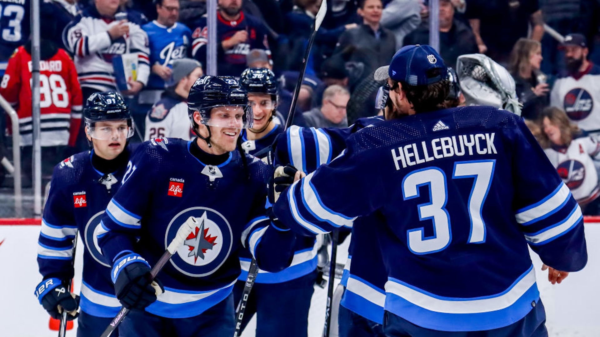 Nikolaj Ehlers #27 and goaltender Connor Hellebuyck #37 of the Winnipeg Jets celebrate with teammates following a 2-1 victory over the Chicago Blackhawks at the Canada Life Centre on January 11, 2024 in Winnipeg, Manitoba, Canada.