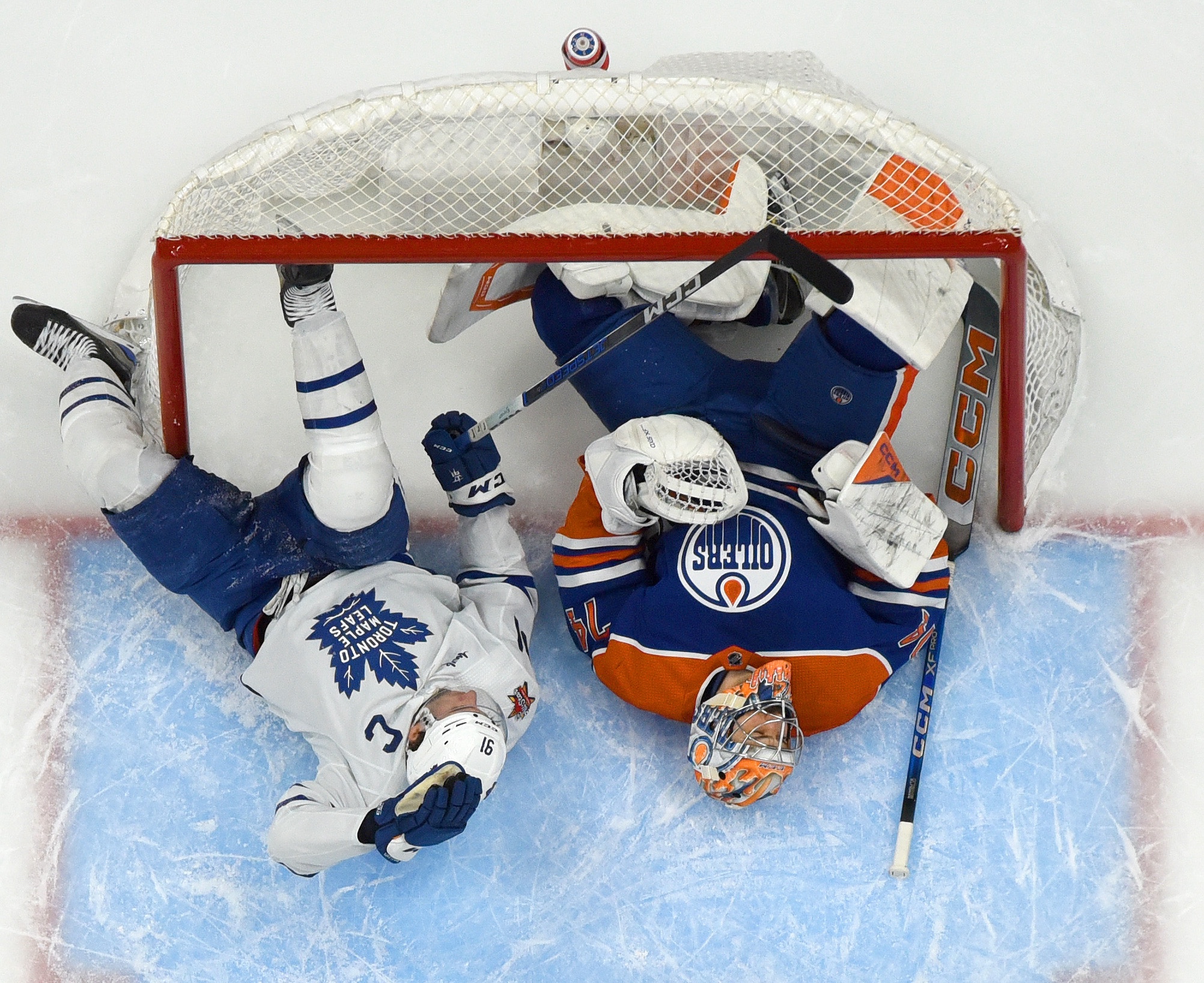 EDMONTON, CANADA - JANUARY 16: John Tavares #91 of the Toronto Maple Leafs collides with goaltender Stuart Skinner #74 of the Edmonton Oilers as they both lay in the net during the game at Rogers Place on January 16, 2024, in Edmonton, Alberta, Canada. (Photo by Andy Devlin/NHLI via Getty Images)