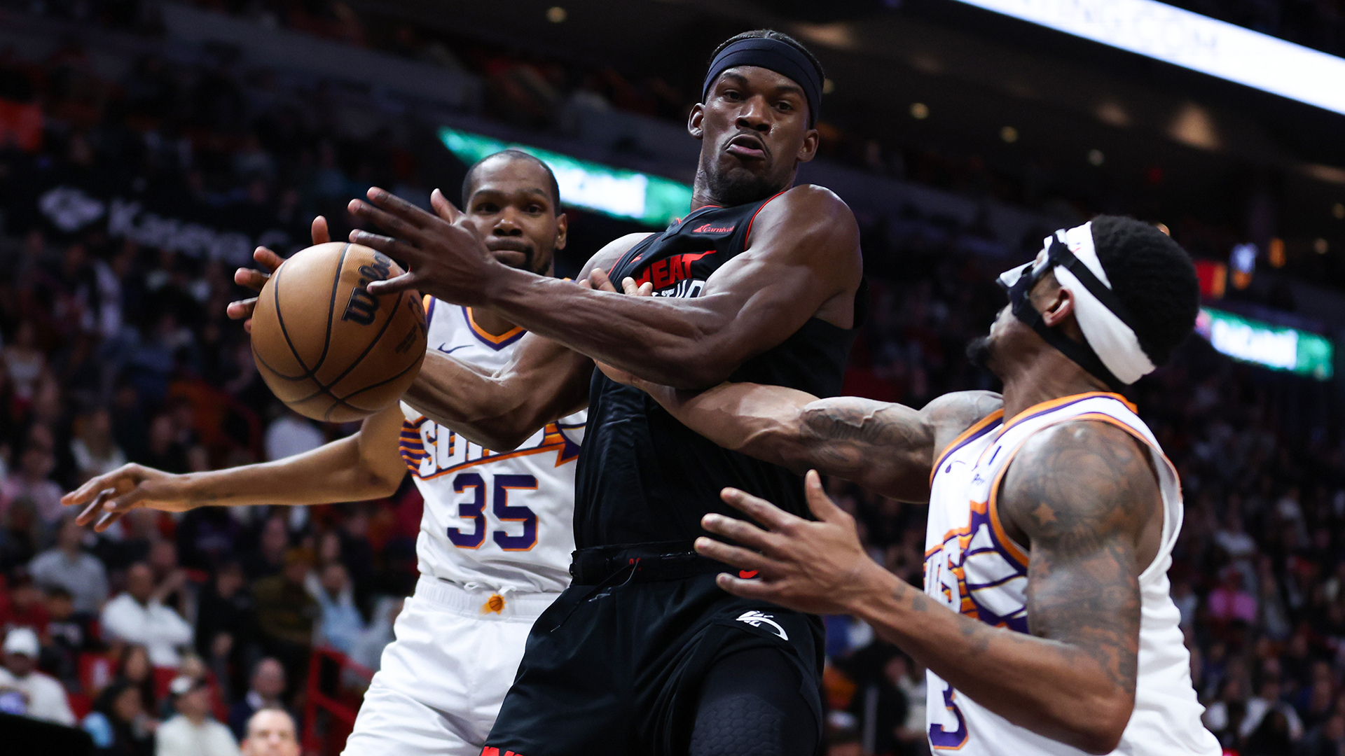 Jimmy Butler #22 of the Miami Heat rebounds the ball against Bradley Beal #3 of the Phoenix Suns during the third quarter of the game at Kaseya Center on January 29, 2024 in Miami,