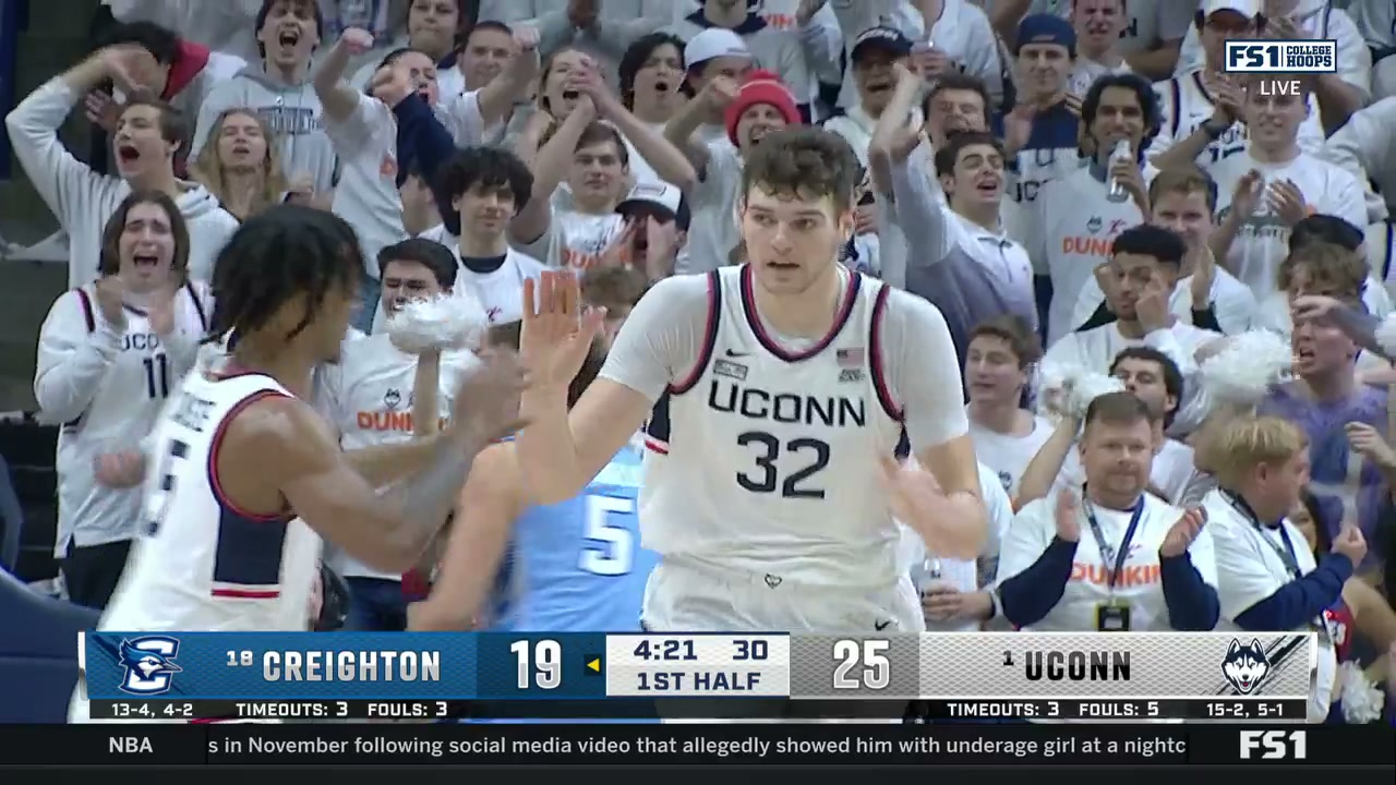 UConn’s Donovan Clingan high-fives a teammate after scoring as the UConn crowd behind him goes wild