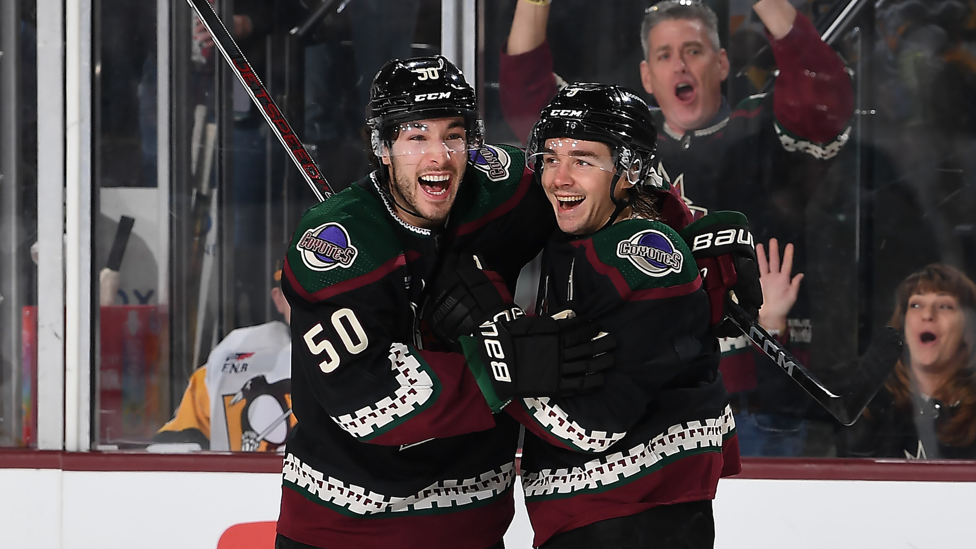 Clayton Keller #9 of the Arizona Coyotes celebrates with teammate Sean Durzi #50 after a goal scored by Lawson Crouse.