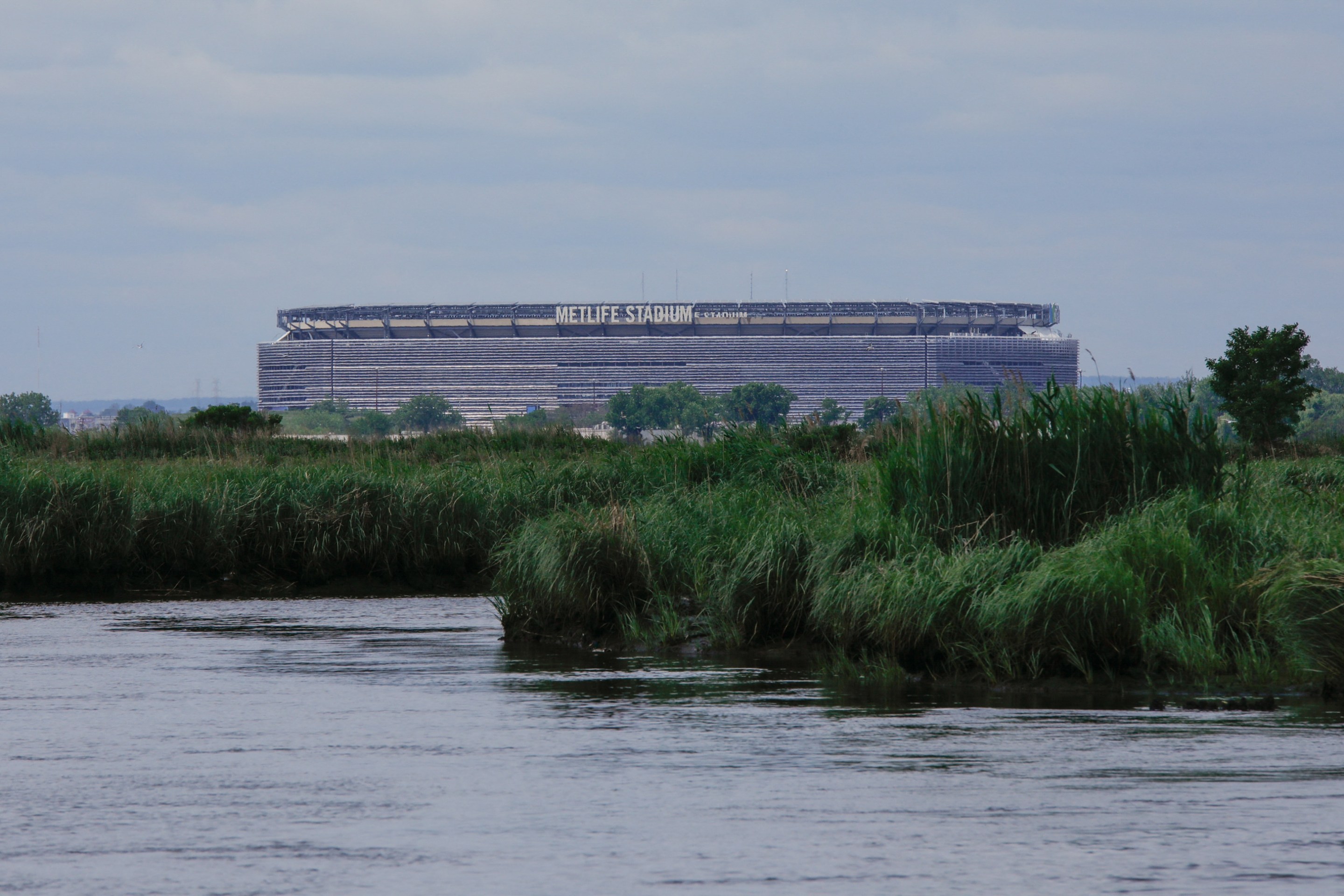 Metlife Stadium across the Hackensack River in Secaucus, New Jersey, on June 15, 2023. Activist Bill Sheehan has turned mountains to clean up the river, polluted by industry, ten kilometers (6.2 miles) from Manhattan, even if much remains to be done. "It didn't take me long to realize that the river needed a full-time advocate," he says of the hemmed in by an ultra-dense urban grid. (Photo by KENA BETANCUR / AFP) (Photo by KENA BETANCUR/AFP via Getty Images)