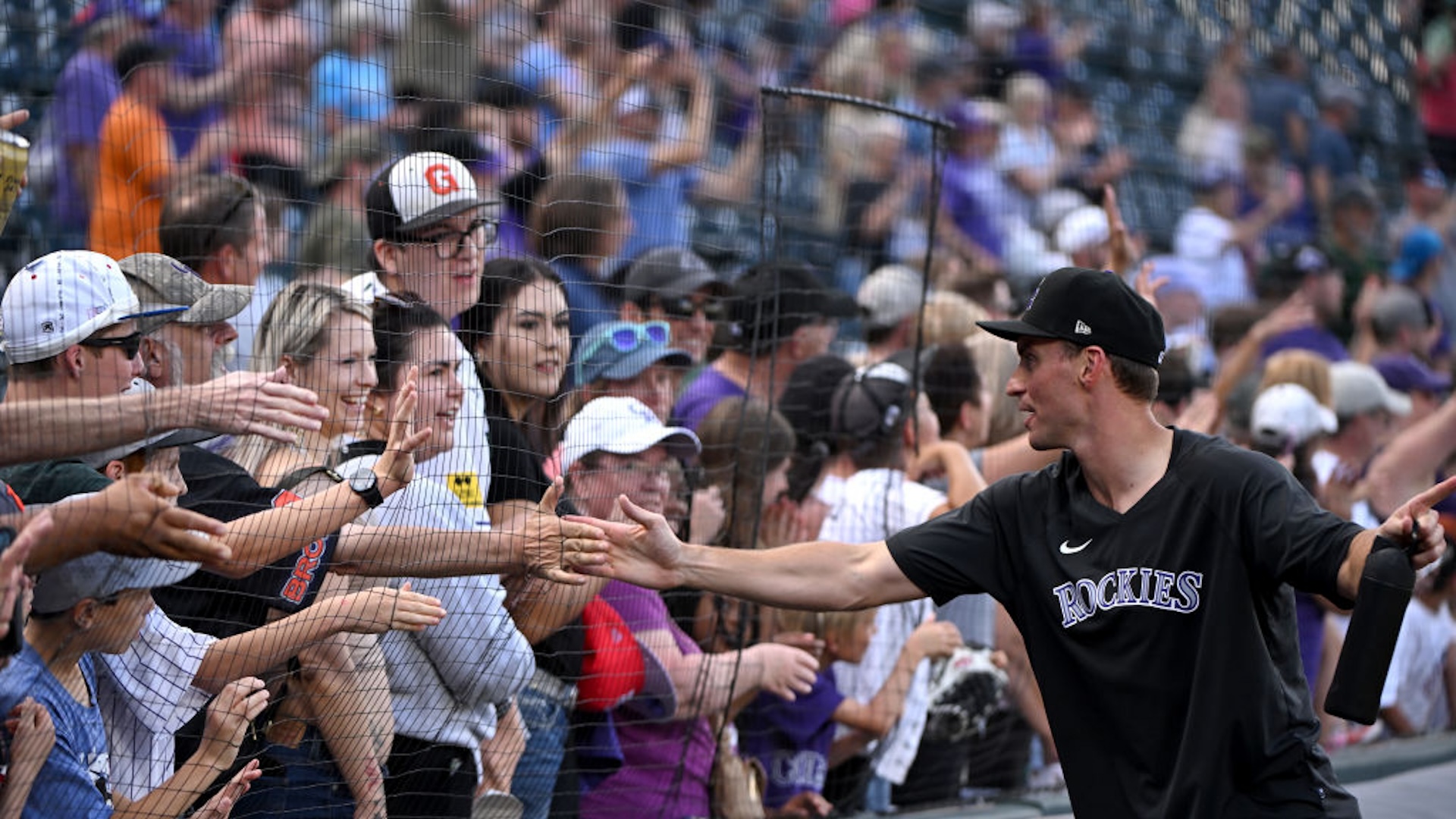 Colorado Rockies relief pitcher Brent Suter high fives fans as he walks around the field with players to end their season at Coors Field on October 1, 2023 in Denver, Colorado.