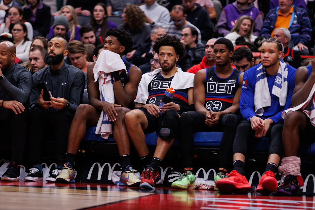 Cade Cunningham, Jaden Ivey and other members of the Detroit Pistons look onto the court from the bench during a game against the Toronto Raptors