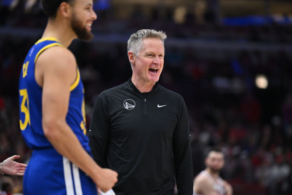 Golden State Warriors head coach Steve Kerr reacts to a play while standing on the sidelines as guard Stephen Curry watches in the foreground during a game against the Chicago Bulls on January 12, 2024.