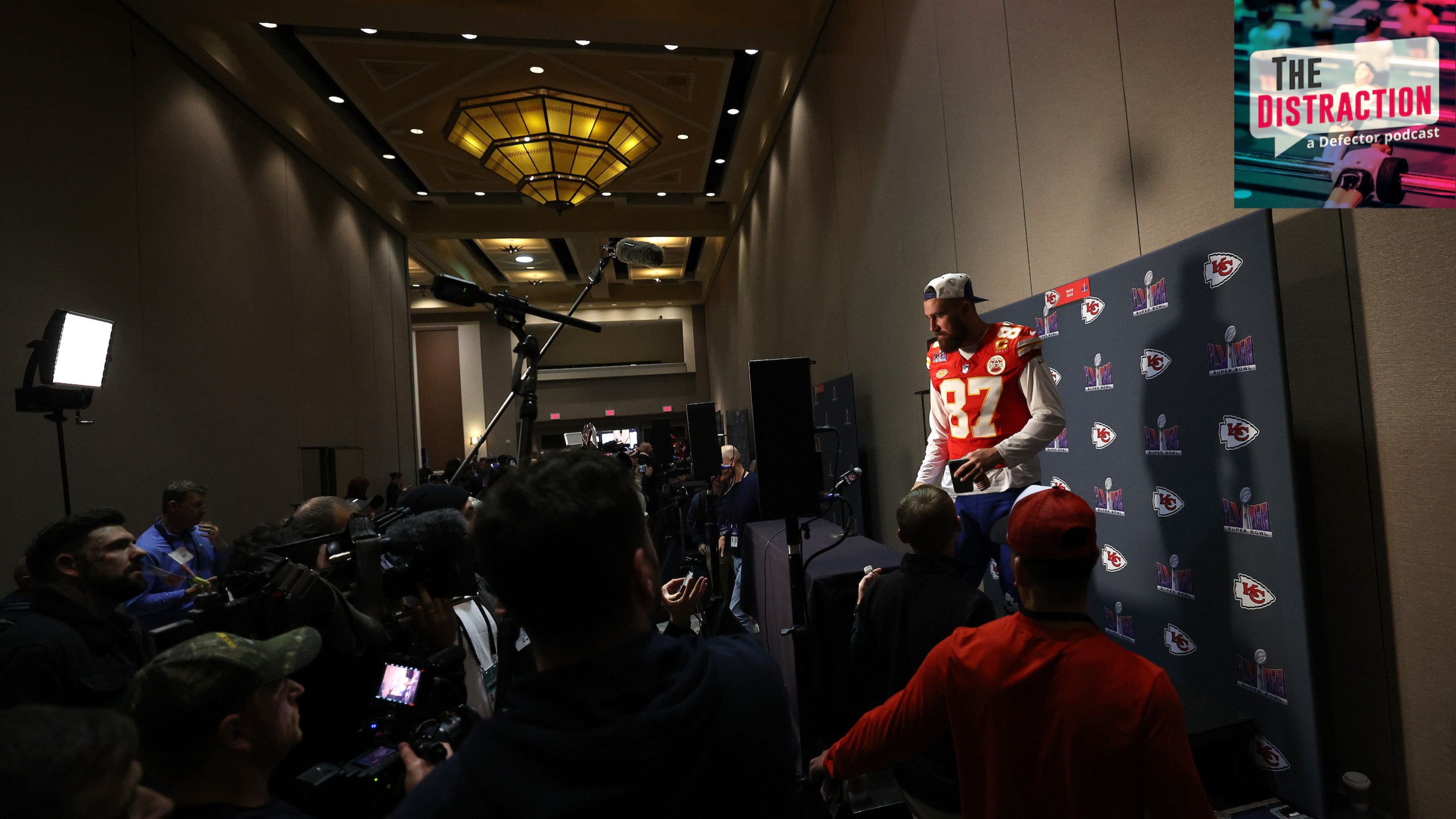 Travis Kelce faces the media during Super Bowl Media Days in the lead up to Super Bowl LVIII. It's pretty dramatically lit for something happening at a Westin in Henderson, Nevada.
