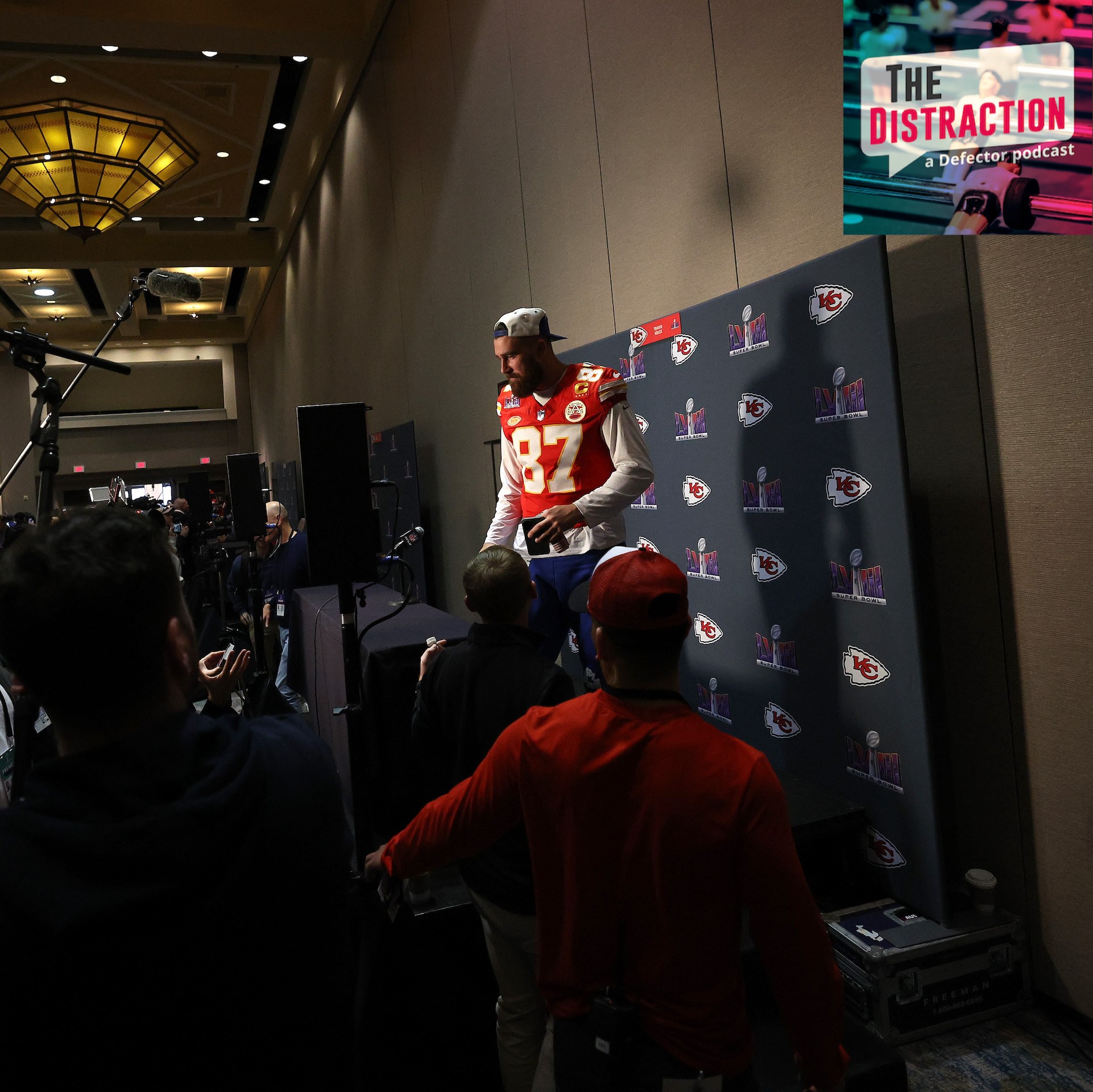 Travis Kelce faces the media during Super Bowl Media Days in the lead up to Super Bowl LVIII. It's pretty dramatically lit for something happening at a Westin in Henderson, Nevada.