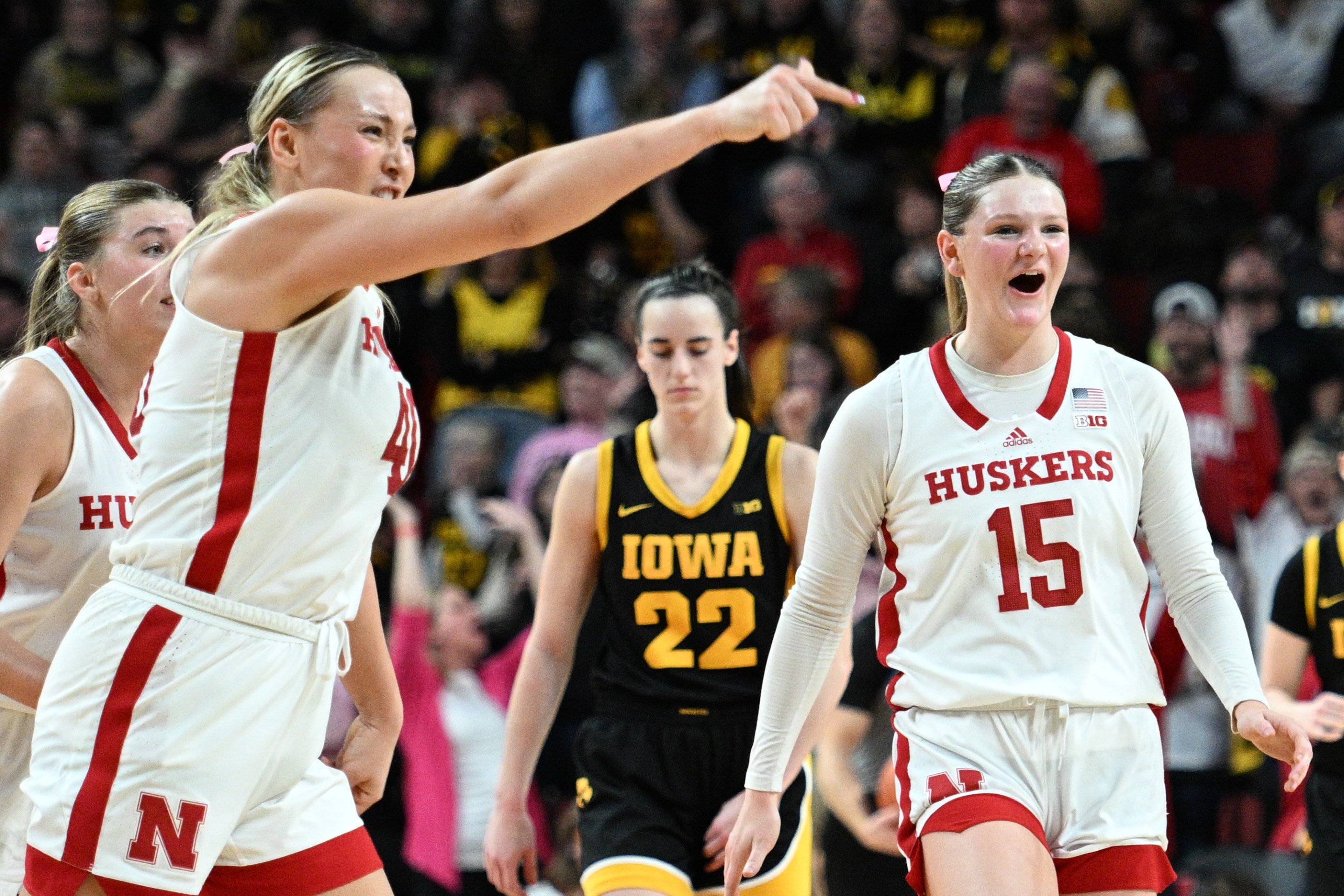 Kendall Moriarty #15 of the Nebraska Cornhuskers and Alexis Markowski #40 celebrate after a basket as Caitlin Clark #22 of the Iowa Hawkeyes looks on in the second half at Pinnacle Bank Arena on February 11, 2024 in Lincoln, Nebraska.