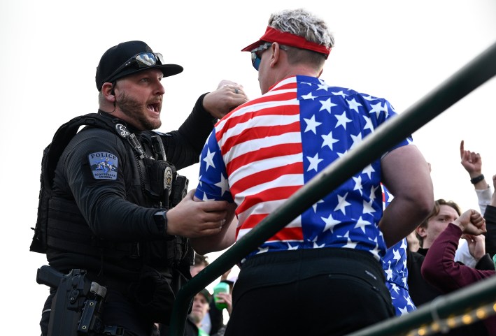 SCOTTSDALE, ARIZONA - FEBRUARY 10: A police officer talks with a fan on the 16th green during the continuation of the second round of the WM Phoenix Open at TPC Scottsdale on February 10, 2024 in Scottsdale, Arizona.