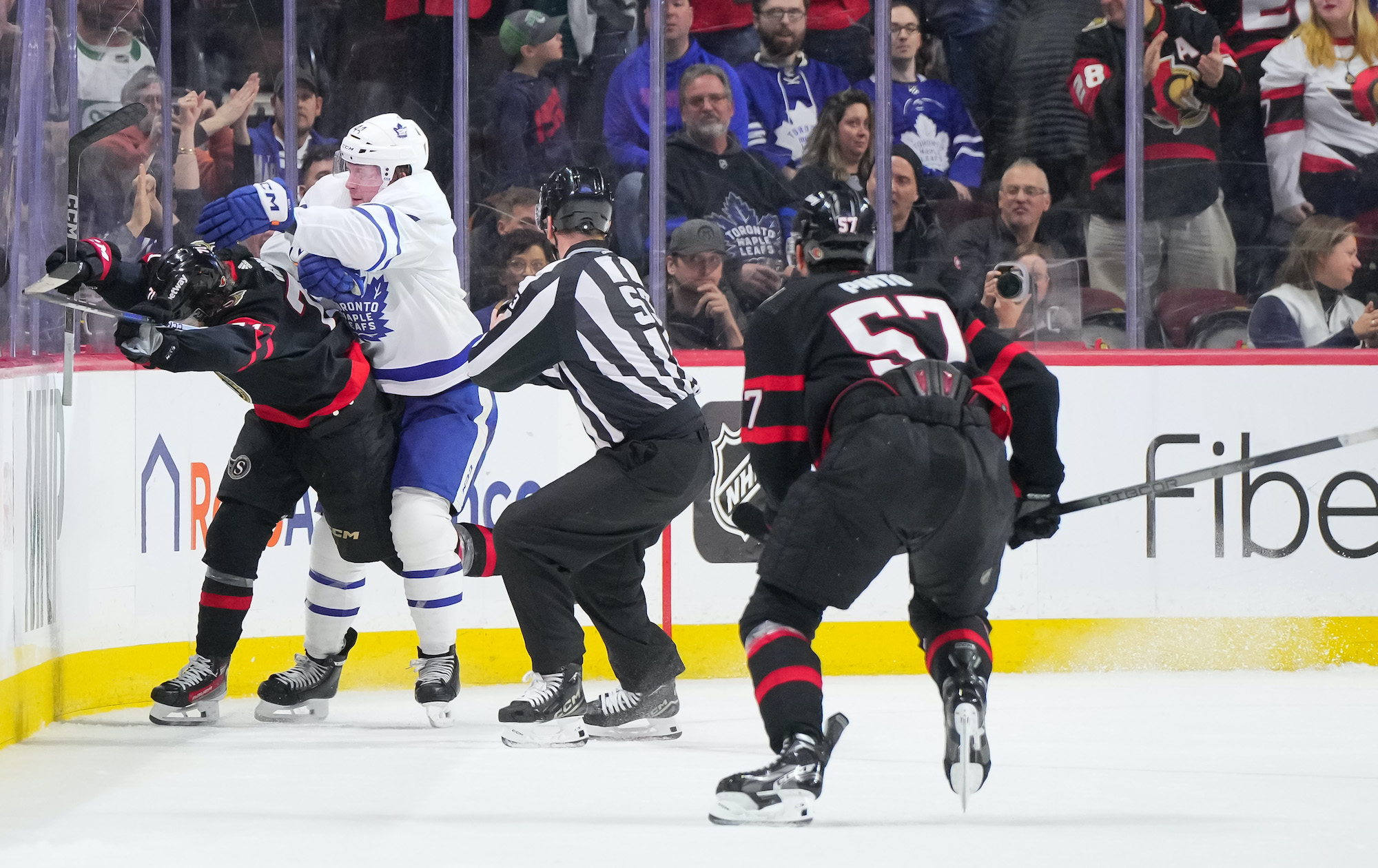 Morgan Rielly cross-checks Ridly Greig after an empty-net slap shot.