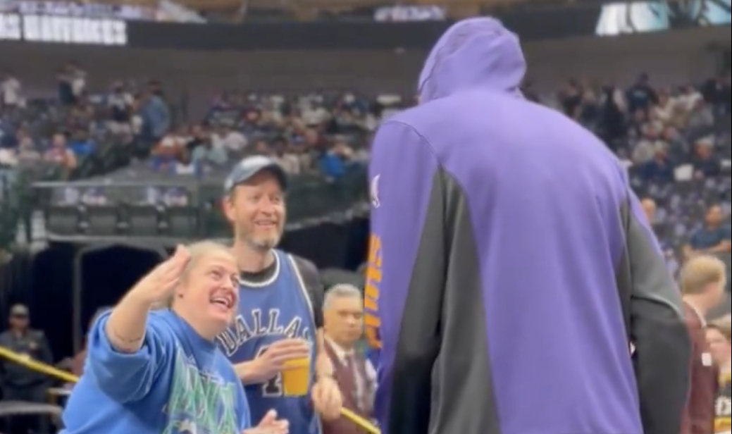 Two Mavericks fans interact with Kevin Durant