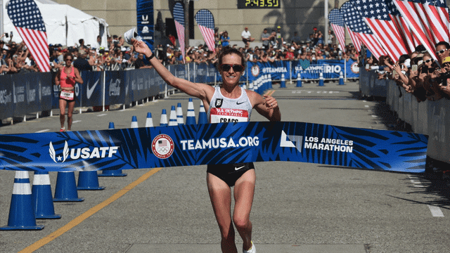 Amy Cragg from Portland, Oregon, celebrates at the finish line after winning the US Women's Marathon Olympic Team Trials with a time of 2:28:27 in Los Angeles, California on February 13, 2016. Highlighted Joanna Zeiger behind her, who finished last, the image is a GIF and zooms into her
