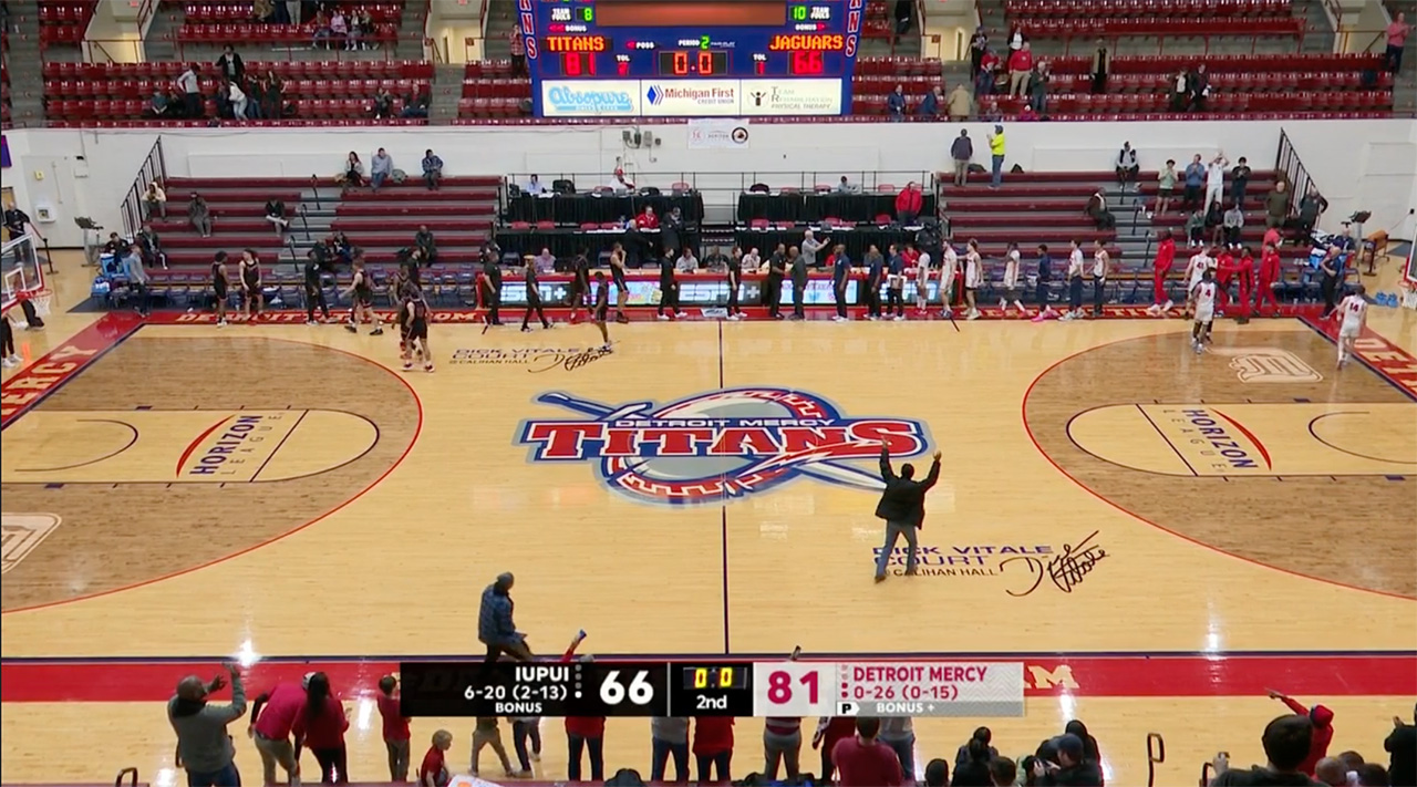 One man rushes onto the court after Detroit Mercy wins its first game of the season.