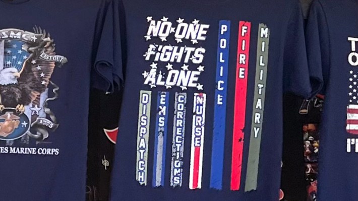 A t-shirt that Dan photographed on the Wildwood boardwalk that looks like a flag and reads "no one fights alone," with the stripes dedicated to "dispatch," EMS, Corrections, Nurse, Police, Fire, and Military.