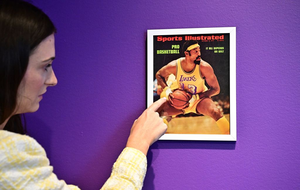 Rose Lobelson, Communications Associate at Sotheby's, points to an image of the Sports Illustrated cover of Wilt Chamberlain in his 'Championship Clinching' 1972 NBA Final jersey, with bandaged-hands after he broke a hand, at Sotheby's Auction House in Beverly Hills, California, on August 1, 2023. The jersey is estimated at $4 million.