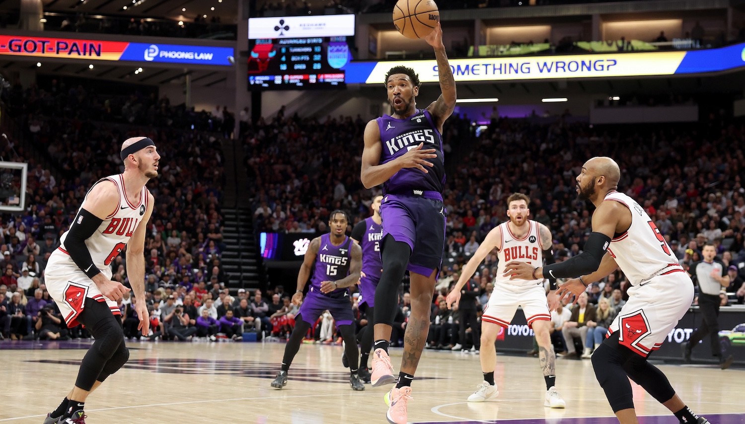 SACRAMENTO, CALIFORNIA - MARCH 04: Malik Monk #0 of the Sacramento Kings passes the ball around Alex Caruso #6 and Jevon Carter #5 of the Chicago Bulls in the second half at Golden 1 Center on March 04, 2024 in Sacramento, California. NOTE TO USER: User expressly acknowledges and agrees that, by downloading and or using this photograph, User is consenting to the terms and conditions of the Getty Images License Agreement. (Photo by Ezra Shaw/Getty Images)