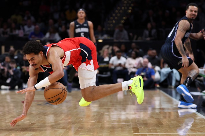 Jordan Poole #13 of the Washington Wizards controls the ball as he falls to the court against the Orlando Magic during the first half at Capital One Arena on March 06, 2024 in Washington, DC.