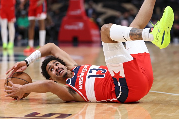 Jordan Poole #13 of the Washington Wizards controls the ball as he falls to the court against the Orlando Magic during the first half at Capital One Arena on March 06, 2024 in Washington, DC.