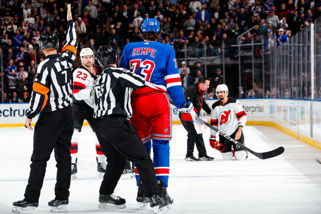 Matt Rempe looks at Jonas Siegenthaler down on the ice