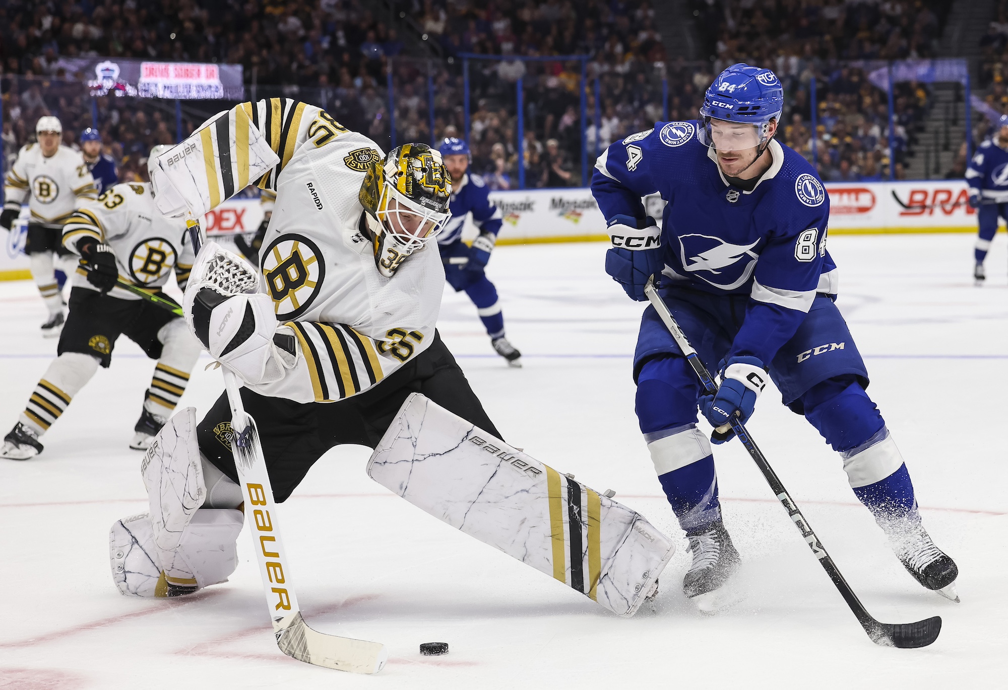 TAMPA, FL - MARCH 27: Tanner Jeannot #84 of the Tampa Bay Lightning battles for the puck against goalie Linus Ullmark #35 of the Boston Bruins during the third period at Amalie Arena on March 27, 2024 in Tampa, Florida. (Photo by Mark LoMoglio/NHLI via Getty Images)