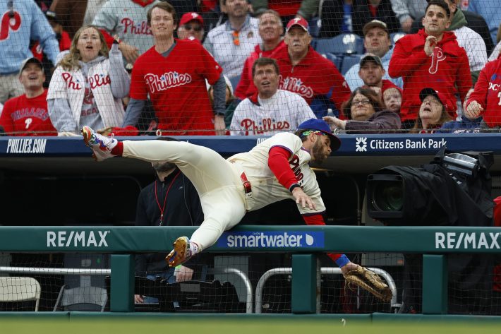 Bryce Harper flips over a wall and into the camera well.