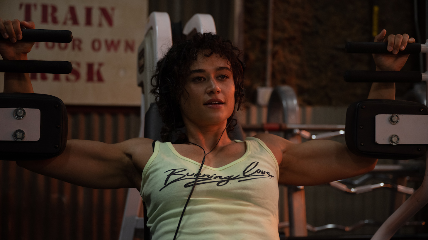 Still image of actress Katy O'Brian using gym equipment, taken from the movie Love Lies Bleeding.