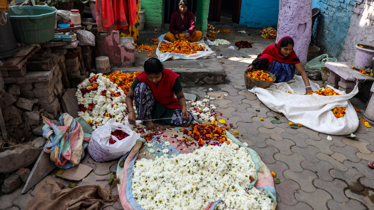 Women prepare garlands for rituals that take place on the riverbank.