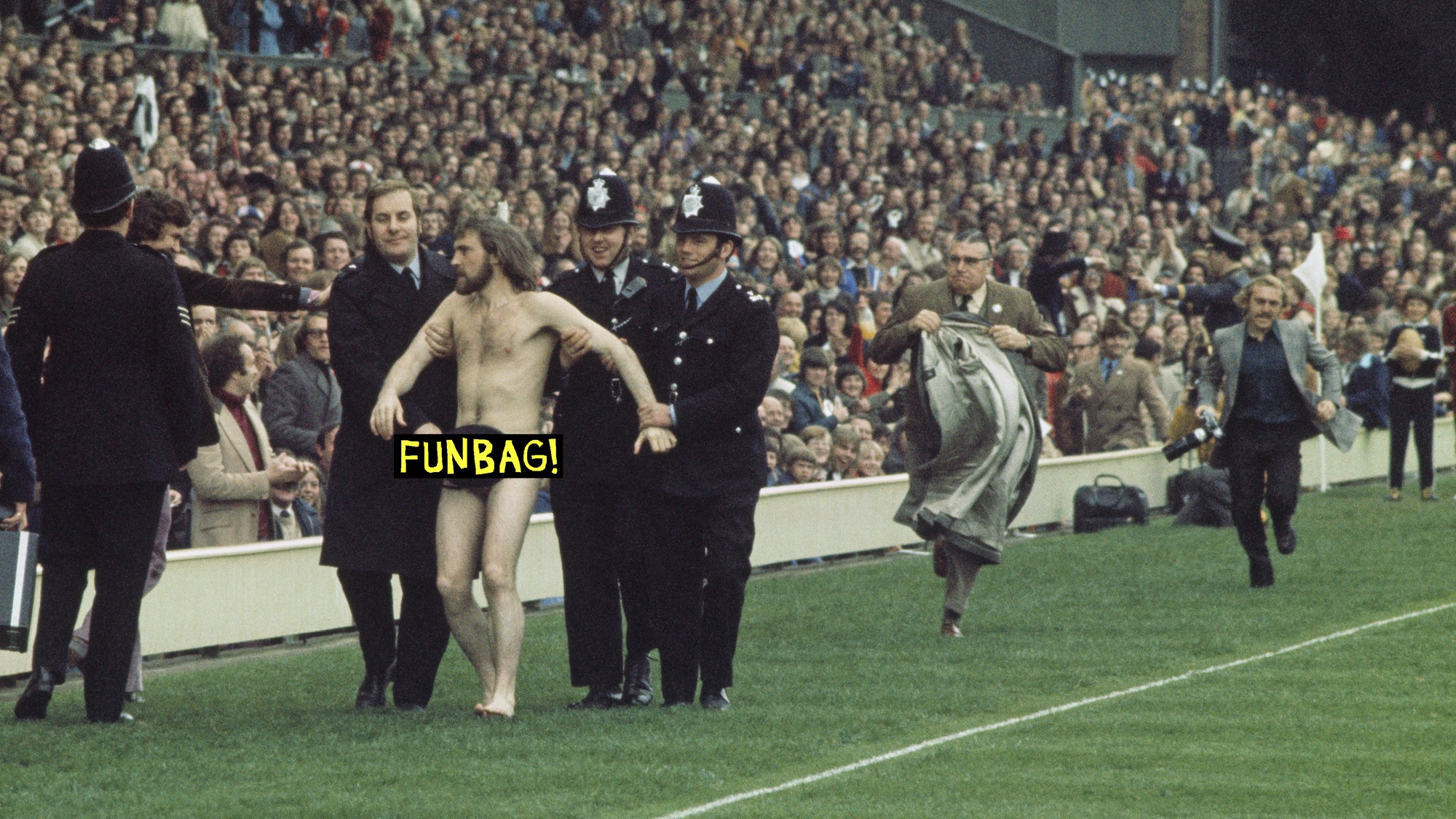 16 Mar 1974: Police Constable Michael O’Brien uses his helmet to cover up streaker Bruce Perry as he is led away during the Five Nations Championship match between England and Wales at Twickenham in London, England. England won the match 16-12. Visions of Sport. (Photo by Tony Duffy/Allsport/Getty Images)