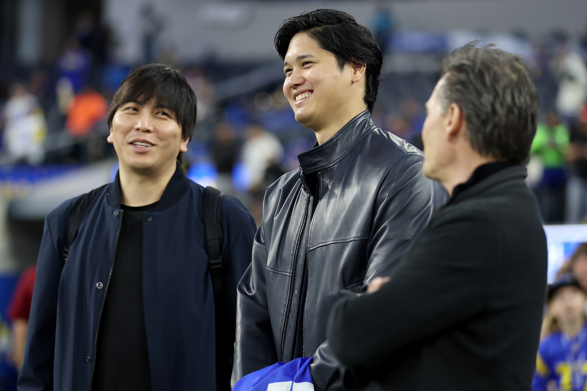 INGLEWOOD, CALIFORNIA - DECEMBER 21: Shohei Ohtani (C) of the Los Angeles Dodgers talks with his interpreter Ippei Mizuhara (L) and agent Nez Balelo (R) prior to the game between the New Orleans Saints and the Los Angeles Rams at SoFi Stadium on December 21, 2023 in Inglewood, California. (Photo by Sean M. Haffey/Getty Images)