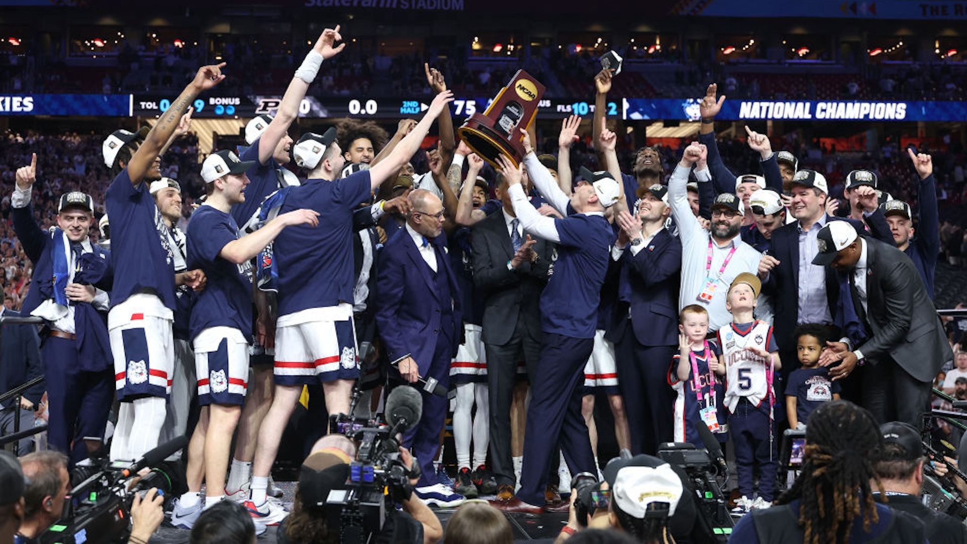 The Connecticut Huskies celebrate with the trophy after beating the Purdue Boilermakers 75-60 to win the NCAA Men's Basketball Tournament National Championship game at State Farm Stadium on April 08, 2024 in Glendale, Arizona.